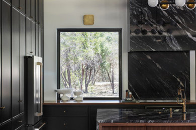This is an example of a large kitchen in Austin with black cabinets and an island.