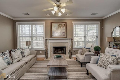 Inspiration for a mid-sized transitional enclosed dark wood floor and brown floor living room remodel in Other with a standard fireplace, a stone fireplace and beige walls