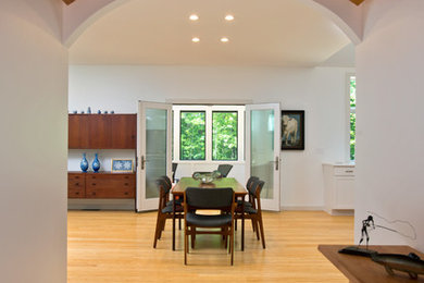 Foyer - small modern light wood floor foyer idea in Boston with white walls