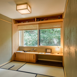 Home studio - mid-sized built-in desk dark wood floor home studio idea in New York with green walls