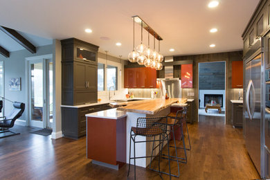 Kitchen - large transitional dark wood floor and brown floor kitchen idea in Cincinnati with shaker cabinets, dark wood cabinets, quartzite countertops, white backsplash, subway tile backsplash, stainless steel appliances and an island
