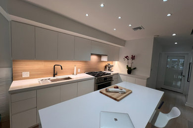 Kitchen - mid-sized modern light wood floor kitchen idea in New York with an undermount sink, flat-panel cabinets, white cabinets, quartzite countertops, porcelain backsplash, stainless steel appliances, an island and white countertops