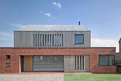 Photo of a red and medium sized contemporary two floor house exterior in London with mixed cladding.