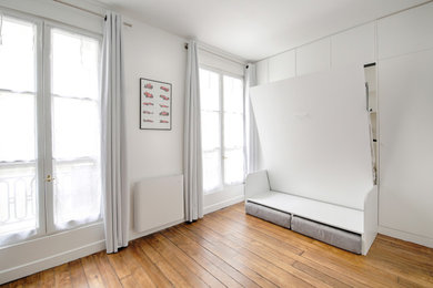 Exemple d'une petite chambre avec un mur blanc et parquet clair.