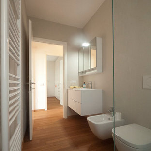 Foto di una stanza da bagno padronale minimalista di medie dimensioni con lavabo integrato, ante lisce, ante bianche, top in quarzo composito, doccia aperta, WC sospeso, piastrelle blu, piastrelle di vetro, pareti beige e pavimento in bambù