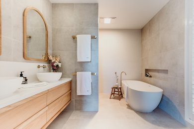 Photo of a contemporary master bathroom in Other with flat-panel cabinets, medium wood cabinets, a freestanding tub, an open shower, gray tile, white walls, a vessel sink, engineered quartz benchtops, grey floor, white benchtops, a double vanity and a floating vanity.