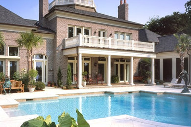 Inspiration for a mid-sized traditional backyard custom-shaped lap pool in Charleston with a water feature and tile.