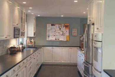 Example of a mid-sized classic l-shaped linoleum floor enclosed kitchen design in New York with an undermount sink, raised-panel cabinets, granite countertops, multicolored backsplash, matchstick tile backsplash and stainless steel appliances