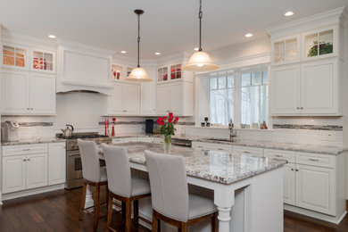 Inspiration for a mid-sized transitional l-shaped dark wood floor kitchen remodel in New York with an undermount sink, raised-panel cabinets, white cabinets, granite countertops, white backsplash, stainless steel appliances and an island