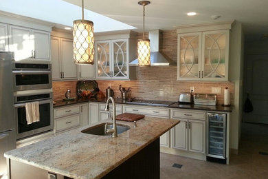 Mid-sized transitional l-shaped ceramic tile enclosed kitchen photo in Philadelphia with an undermount sink, recessed-panel cabinets, beige cabinets, granite countertops, brown backsplash, matchstick tile backsplash, stainless steel appliances and an island