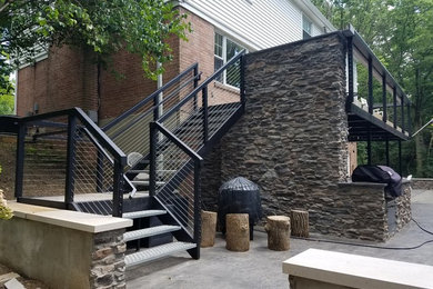 Large minimalist metal l-shaped metal railing and open staircase photo in Other