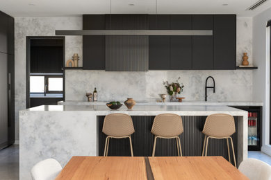 Photo of a contemporary eat-in kitchen in Perth with black cabinets, solid surface benchtops, grey splashback, stone slab splashback, black appliances, with island and grey benchtop.