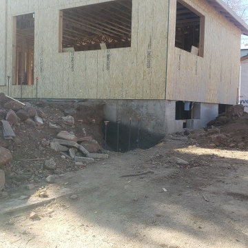 Mountain inspired minimalist boulder retaining walls and plantings.