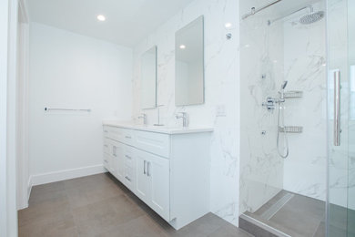 Bathroom - large modern master white tile and porcelain tile porcelain tile, gray floor and double-sink bathroom idea with furniture-like cabinets, white cabinets, a one-piece toilet, white walls, an undermount sink, quartzite countertops, white countertops and a freestanding vanity