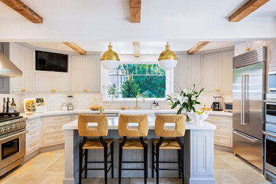 Transitional u-shaped kitchen in Los Angeles with a farmhouse sink, recessed-panel cabinets, grey cabinets, stainless steel appliances, with island, beige floor, white benchtop and exposed beam.