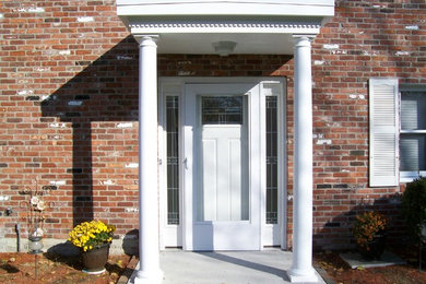 Mid-sized concrete floor entryway photo in Boston with white walls and a white front door