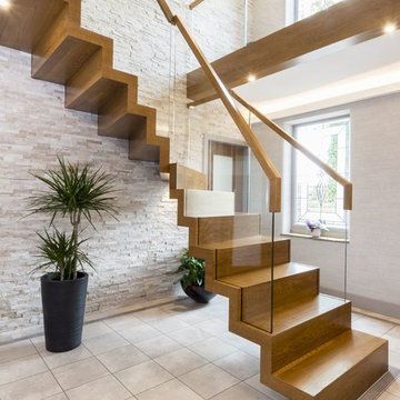 Freitragende Faltwerktreppe aus Holz mit Glasgeländer