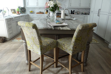 Eat-in kitchen - large traditional u-shaped medium tone wood floor and brown floor eat-in kitchen idea in Tampa with white cabinets, white backsplash, stainless steel appliances, an island, a farmhouse sink, recessed-panel cabinets, marble countertops and mosaic tile backsplash