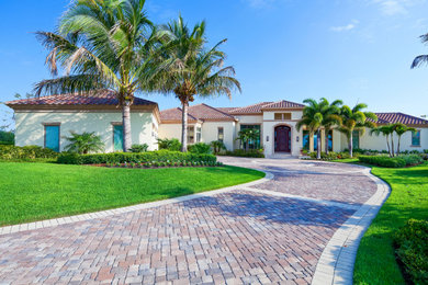 Design ideas for a large mediterranean full sun front yard concrete paver driveway in Tampa for summer.