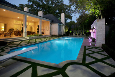 This is an example of a mid-sized traditional backyard rectangular pool in Dallas with concrete slab.