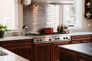 Transitional eat-in kitchen photo in Atlanta with dark wood cabinets, metallic backsplash, metal backsplash, stainless steel appliances and white countertops