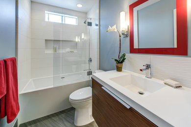 Example of a mid-sized zen white tile and ceramic tile porcelain tile, gray floor and single-sink bathroom design in San Francisco with flat-panel cabinets, brown cabinets, a two-piece toilet, blue walls, an integrated sink, solid surface countertops, white countertops, a niche and a floating vanity