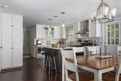 Inspiration for a mid-sized transitional l-shaped eat-in kitchen in DC Metro with an undermount sink, shaker cabinets, white cabinets, quartz benchtops, white splashback, stone tile splashback, stainless steel appliances, dark hardwood floors and with island.