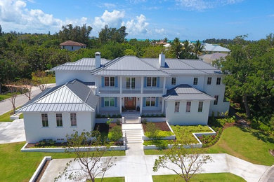 Inspiration for a large transitional white two-story stucco house exterior remodel in Tampa with a metal roof