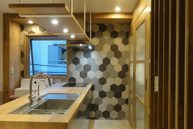 Photo of a mid-sized modern galley eat-in kitchen in Tokyo with stainless steel cabinets, wood benchtops, beige splashback, timber splashback, stainless steel appliances, marble floors, with island and beige floor.