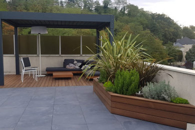 Modern patio in Paris with decking and a pergola.