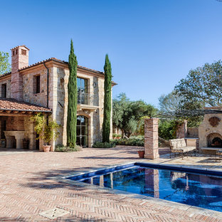 Design ideas for a large country backyard rectangular lap pool in Orange County with a hot tub and brick pavers.