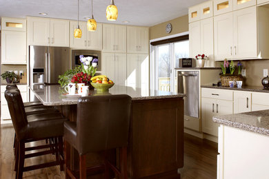 Example of a mid-sized classic u-shaped dark wood floor and brown floor enclosed kitchen design in Chicago with a double-bowl sink, white cabinets, granite countertops, stainless steel appliances, an island, raised-panel cabinets and beige backsplash