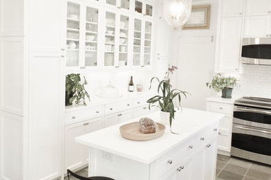 Kitchen pantry - mid-sized traditional l-shaped limestone floor and gray floor kitchen pantry idea in Hawaii with an undermount sink, shaker cabinets, white cabinets, laminate countertops, white backsplash, ceramic backsplash, stainless steel appliances and an island