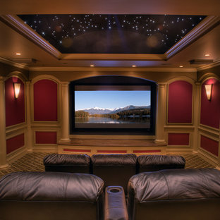 Réalisation d'une grande salle de cinéma tradition fermée avec un mur rouge, moquette, un écran de projection et un sol multicolore.