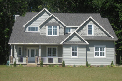 Example of a mid-sized classic gray two-story vinyl exterior home design in Other with a hip roof