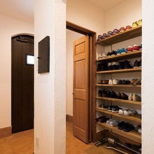 横浜の片開きドアトラディショナルスタイルのおしゃれな玄関 (白い壁、テラコッタタイルの床、黒いドア、茶色い床) の写真