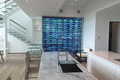 Wine cellar - small modern light wood floor wine cellar idea in Miami