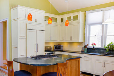 Eat-in kitchen - mid-sized transitional u-shaped light wood floor eat-in kitchen idea in Boston with an undermount sink, shaker cabinets, white cabinets, granite countertops, white backsplash, subway tile backsplash, stainless steel appliances and an island