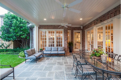 Large transitional backyard tile patio photo in Houston with a roof extension