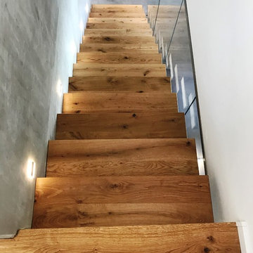 Kragarmtreppe mit deckenhoher Glaswand