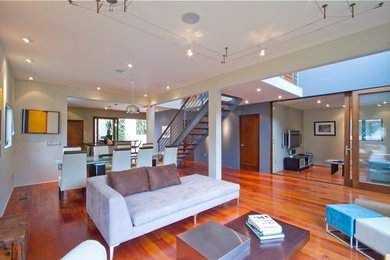 Living room - large contemporary open concept medium tone wood floor living room idea in Los Angeles with gray walls, no fireplace and a wall-mounted tv