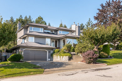 Mid-sized transitional gray three-story stucco house exterior idea in Vancouver with a shingle roof