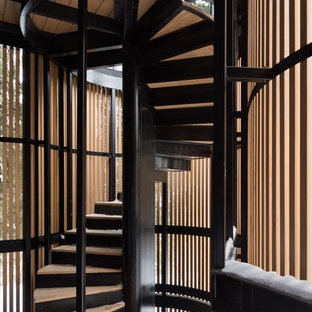 На фото: винтовая лестница в современном стиле с деревянными ступенями, металлическими подступенками и металлическими перилами с