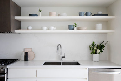 Mid-sized minimalist single-wall eat-in kitchen photo in Vancouver with a double-bowl sink, white cabinets, quartz countertops, quartz backsplash and an island