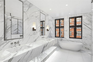 Design ideas for a medium sized modern ensuite bathroom in London with open cabinets, white cabinets, a freestanding bath, a built-in shower, white tiles, marble tiles, marble worktops, an open shower, white worktops, double sinks and a built in vanity unit.