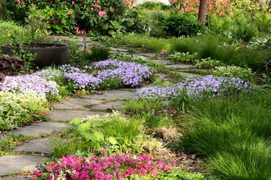 Modelo de jardín de secano tradicional renovado de tamaño medio en primavera en patio delantero con parterre de flores, exposición parcial al sol y adoquines de piedra natural
