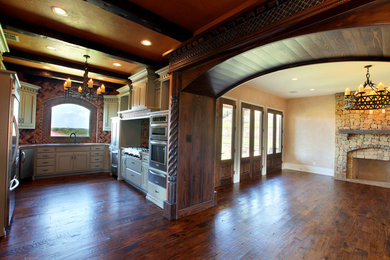 Inspiration for a large mediterranean medium tone wood floor eat-in kitchen remodel in Dallas with a single-bowl sink, recessed-panel cabinets, distressed cabinets, granite countertops, multicolored backsplash, stainless steel appliances and no island