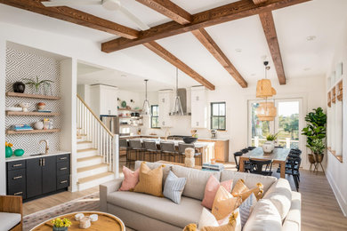 Beach style brown floor living room photo in Charleston with white walls