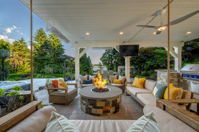 Photo of a mid-sized traditional partial sun backyard stone landscaping in Seattle with a fire pit.