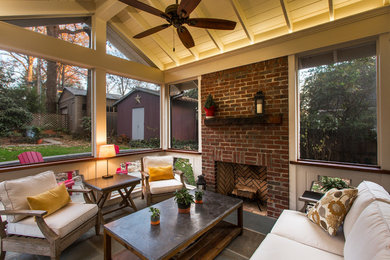 This is an example of a transitional backyard screened-in verandah in Charlotte with natural stone pavers.